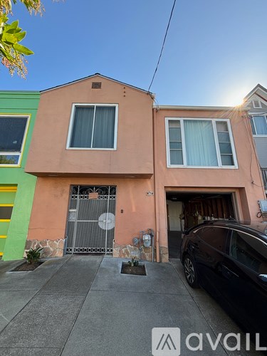 A two-story house with a black car parked in front.
