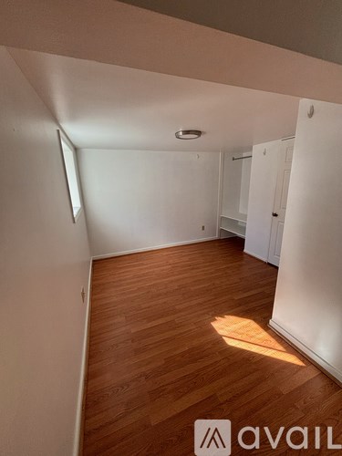 A room with wooden flooring and white walls.