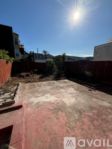A sunny day with a clear blue sky and a red fence in the foreground.