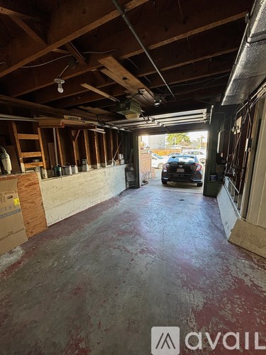 A large empty room with a car in the background.