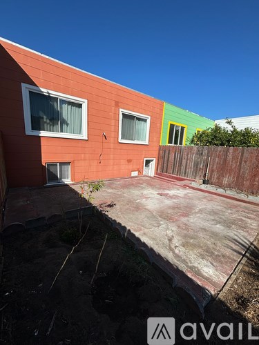 A red and green building with a wooden fence in front.