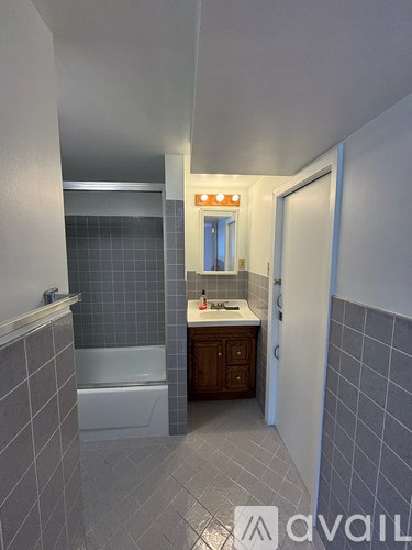 A bathroom with a tub, sink and mirror.