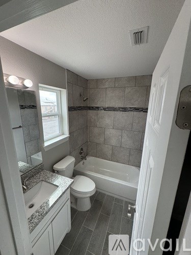 A bathroom with a toilet, sink, and bathtub.