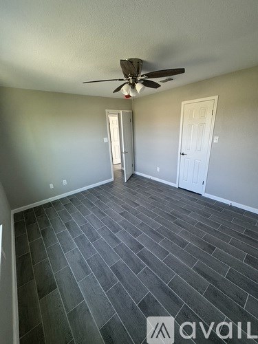 A room with a ceiling fan and two doors.