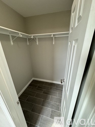 A hallway with a tiled floor and white walls.