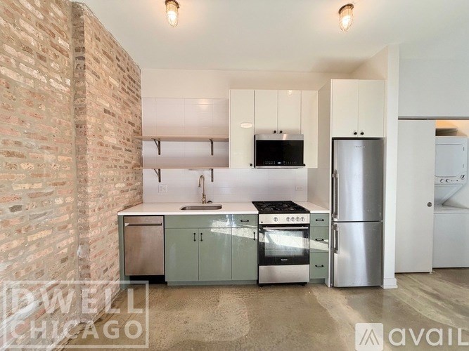 A kitchen with a brick wall and stainless steel appliances.
