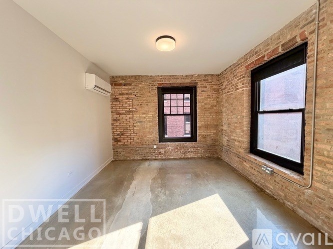 A room with a brick wall and a window with bars on it.
