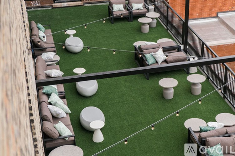 A patio with a green lawn and white furniture.