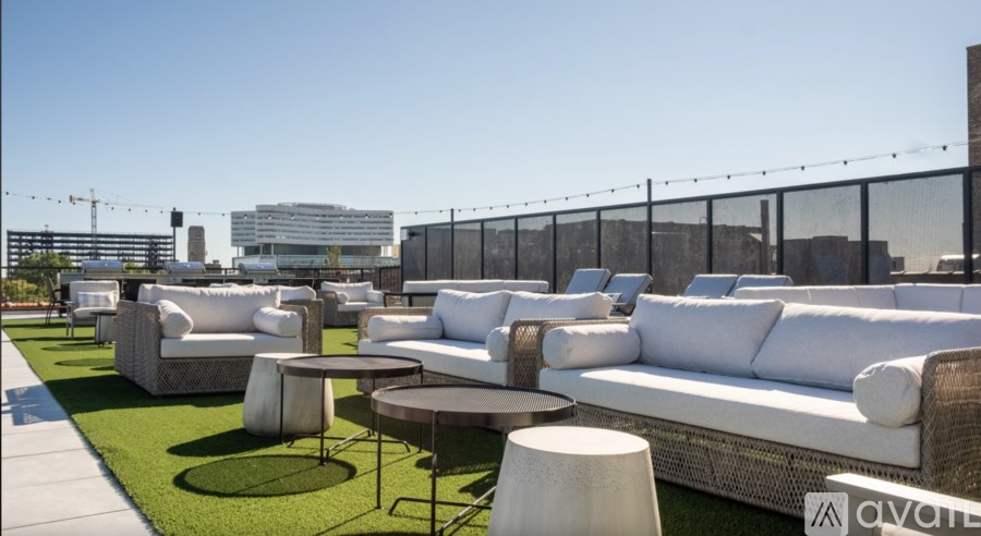 A white outdoor seating area with tables and chairs.