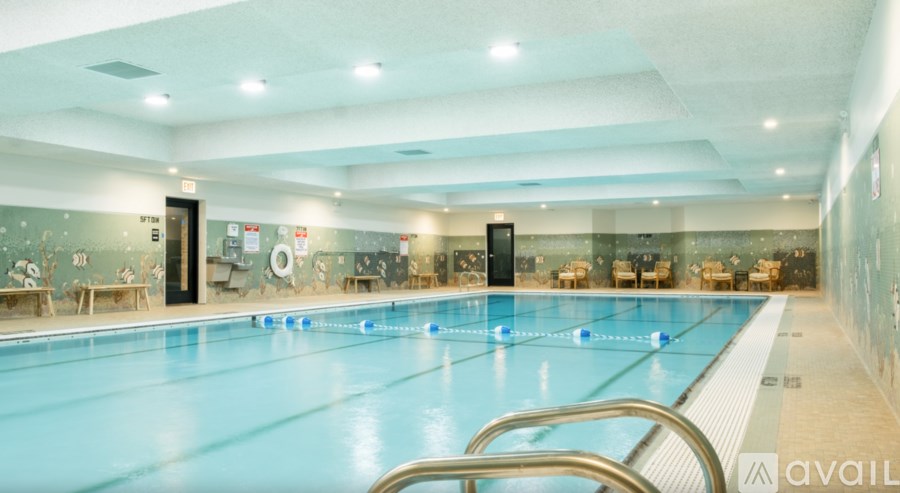 A large indoor swimming pool with a blue tinted water.