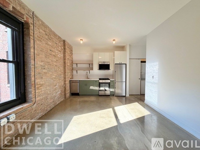 A spacious kitchen with a brick wall and a large window.
