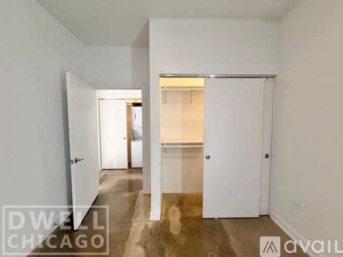 A room with white walls and a marble floor with a doorway leading to another room.