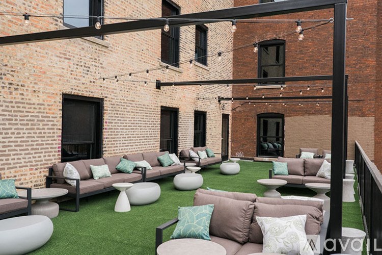 A patio with a black metal frame and a green lawn.