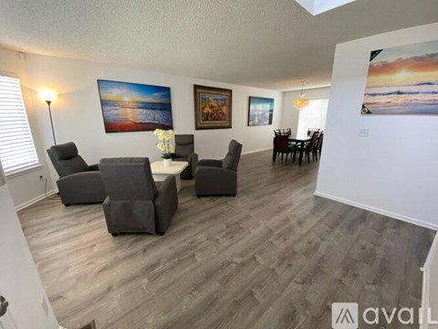 A living room with a grey sofa, two chairs and a dining table.