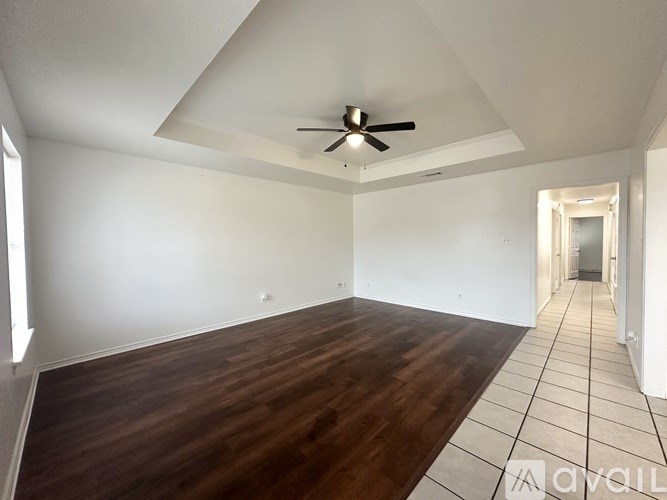 A room with wooden flooring and a ceiling fan.