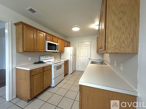 A kitchen with wooden cabinets and white appliances.