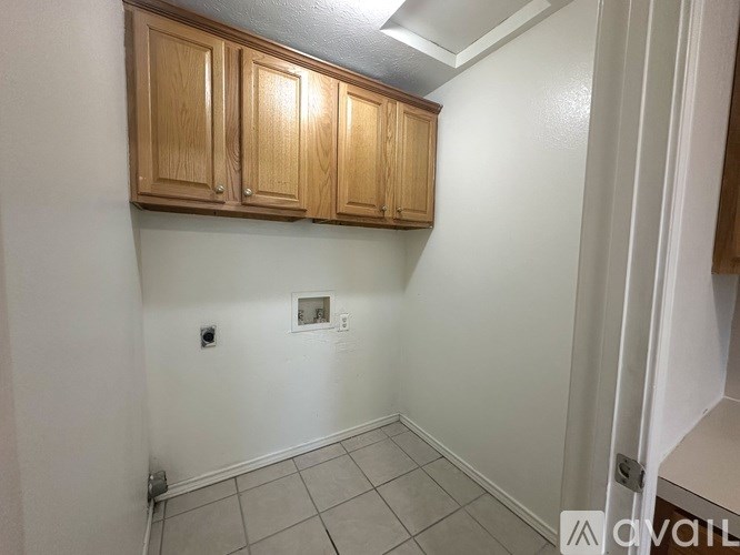 A room with wooden cabinets and a tiled floor.