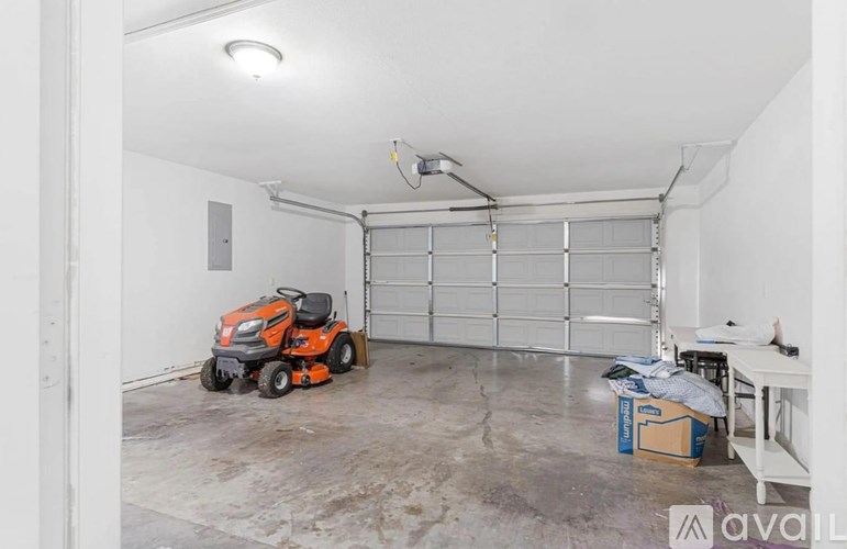 A room with a riding lawn mower inside.