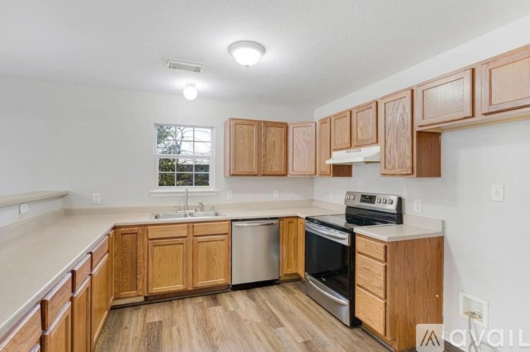 A kitchen with wooden cabinets and a stainless steel dishwasher.