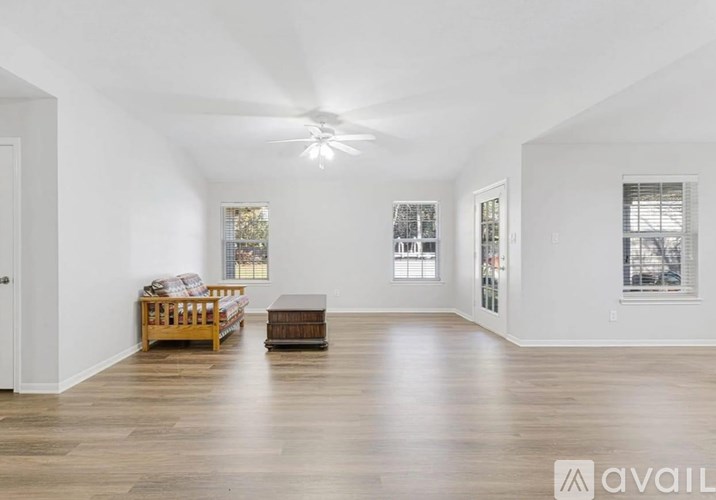 A spacious room with a ceiling fan and a wooden bench.