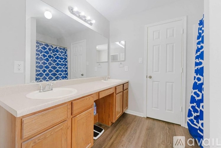 A bathroom with a white sink and wooden cabinets.