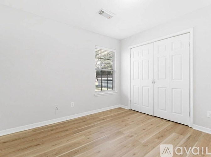 A room with a white door and a window with bars on it.