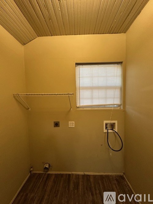 A room with a window and a wooden floor.