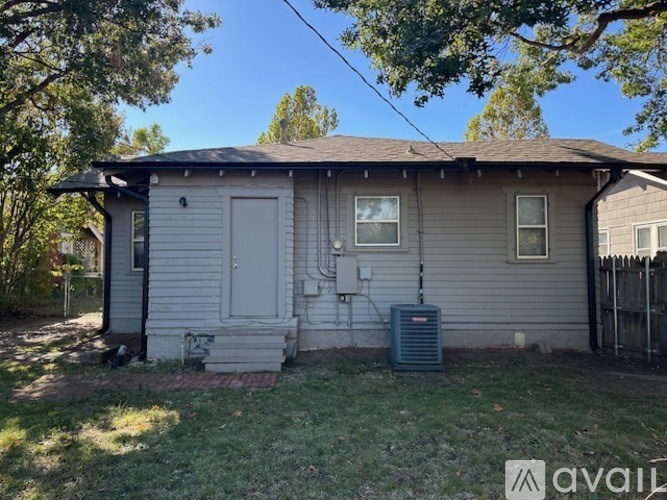 A house with a gray siding and a white door is for sale.
