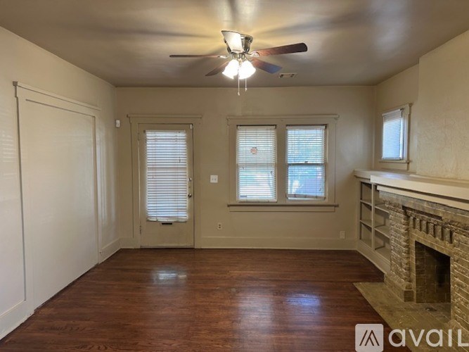 A room with a fireplace and a ceiling fan.