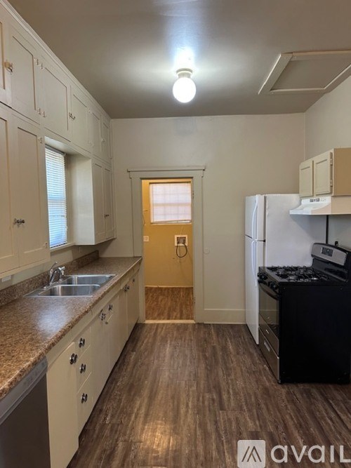 A kitchen with white cabinets and a black stove top oven.