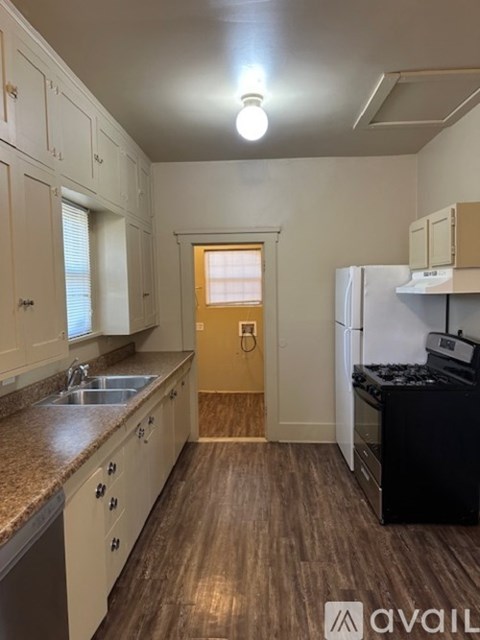 A kitchen with white cabinets and a black stove top oven.