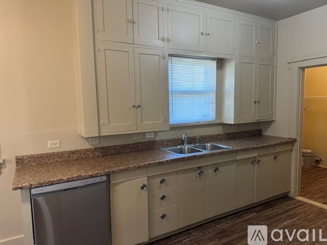 A kitchen with white cabinets and a granite countertop.