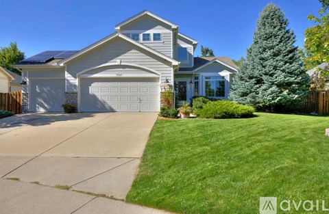 A house with a garage and a driveway in front of it.