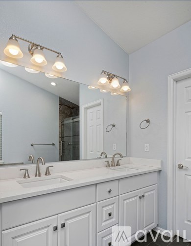 A bathroom with a white vanity and a mirror above it.
