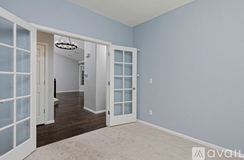 A room with a white door and a chandelier.