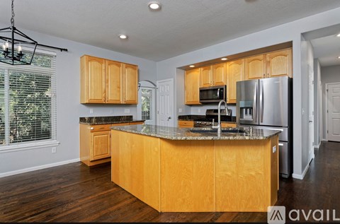 A kitchen with wooden cabinets and a granite countertop.