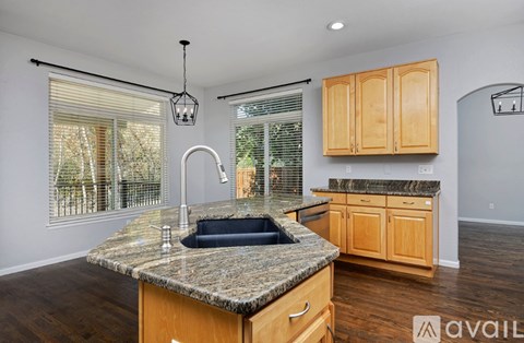 A kitchen with granite countertops and wooden cabinets.