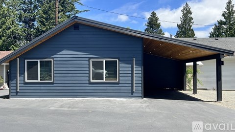 A blue house with a garage door open.