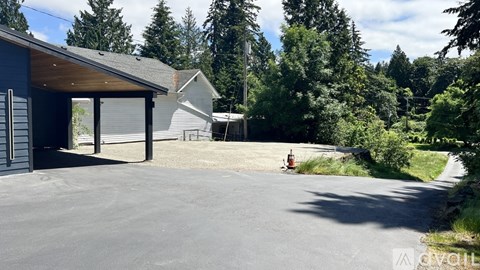 A house with a garage is surrounded by trees.