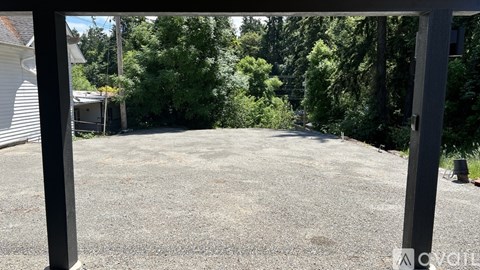 A gravel driveway leads to a house with a white garage door.