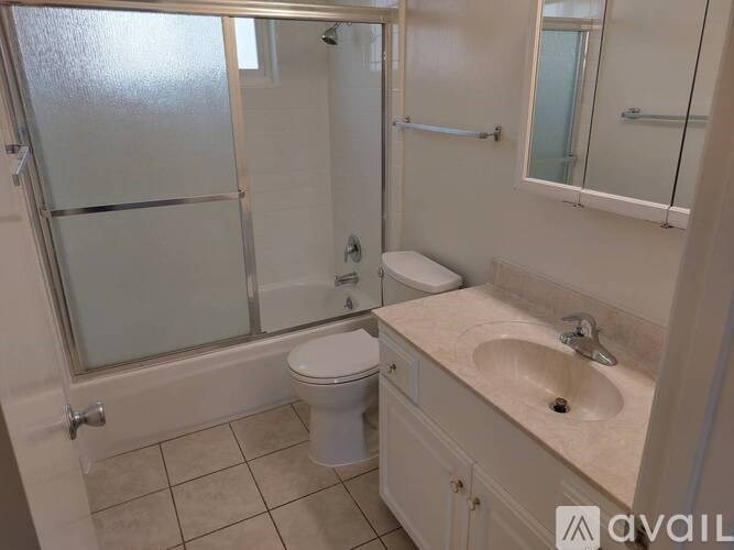 A bathroom with a toilet, sink, and shower.