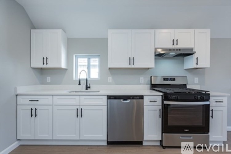 A kitchen with white cabinets and appliances.