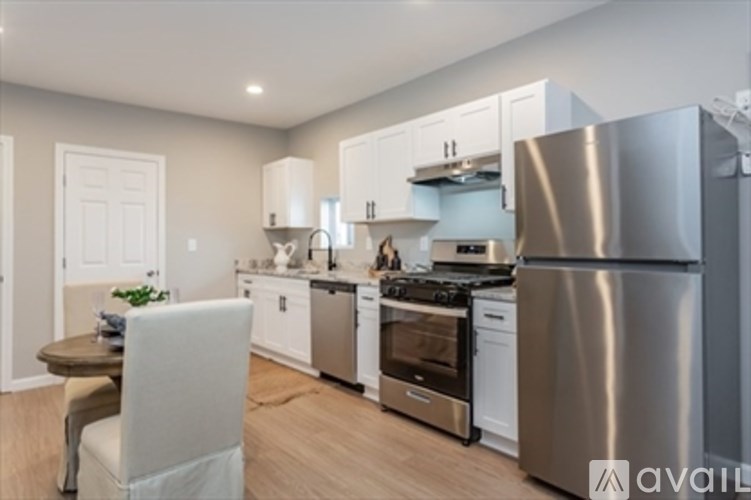 A modern kitchen with stainless steel appliances and white cabinets.