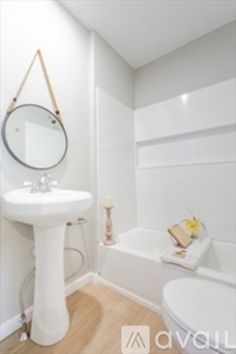 A white bathroom with a pedestal sink and a bathtub.