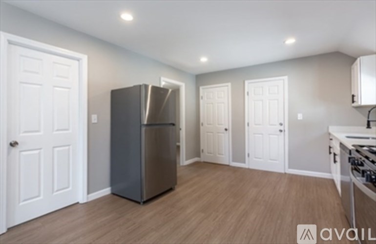 A kitchen with a refrigerator, a stove, and a white door.