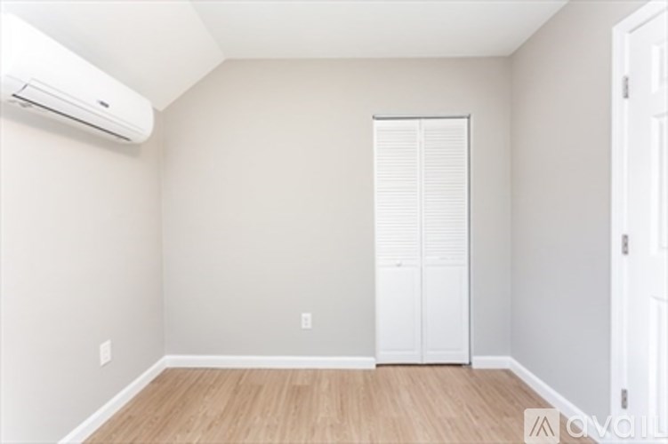A room with a white door and a window with blinds.