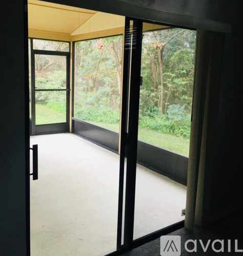 A room with a view of a garden through large windows.