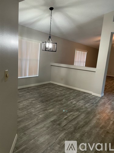 A room with wooden flooring and a hanging light fixture.
