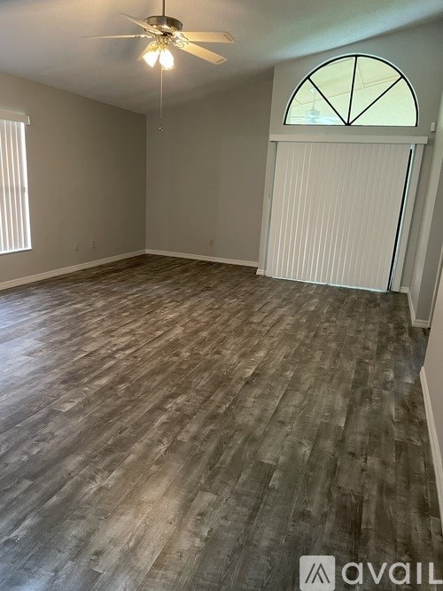 A room with wooden flooring and a ceiling fan.