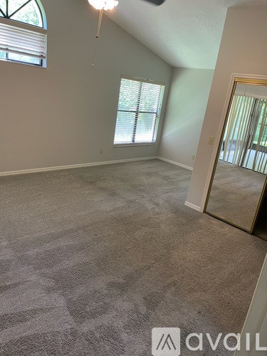 A room with a carpeted floor and a large mirror on the wall.